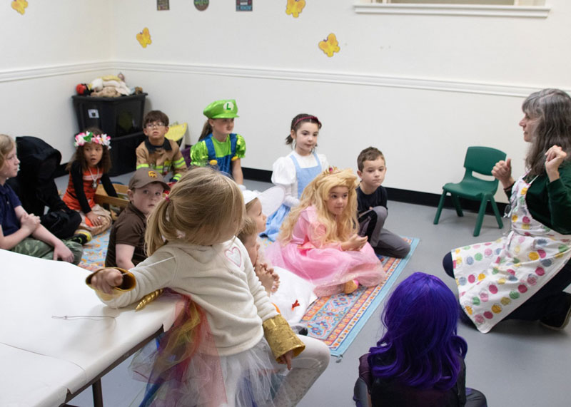 Young students dressed in costum listening to story time
